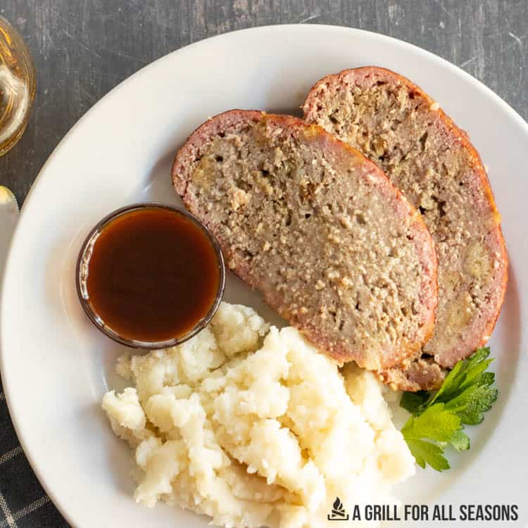 plate with slices of traeger meatloaf and mashed potatoes