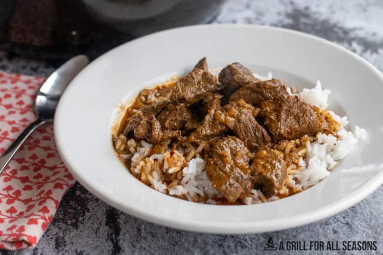beef masala plated with white rice in a white bowl