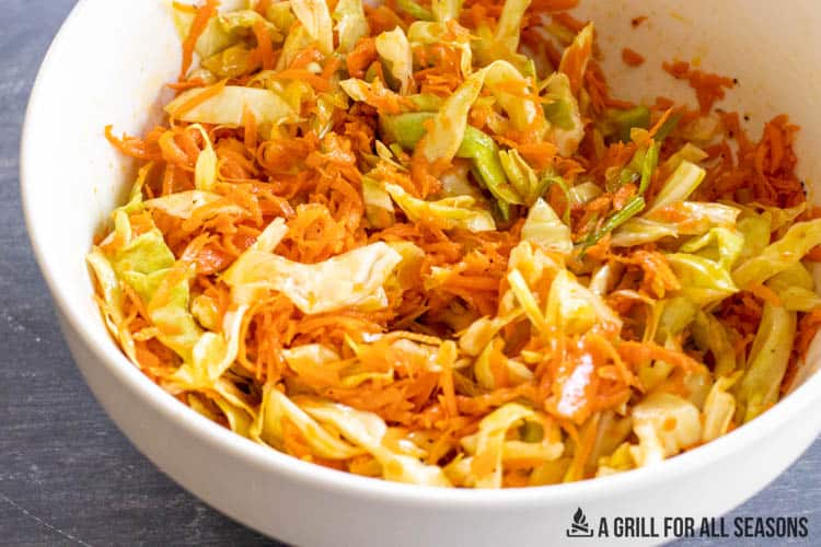 cabbage and carrot salad in a white bowl