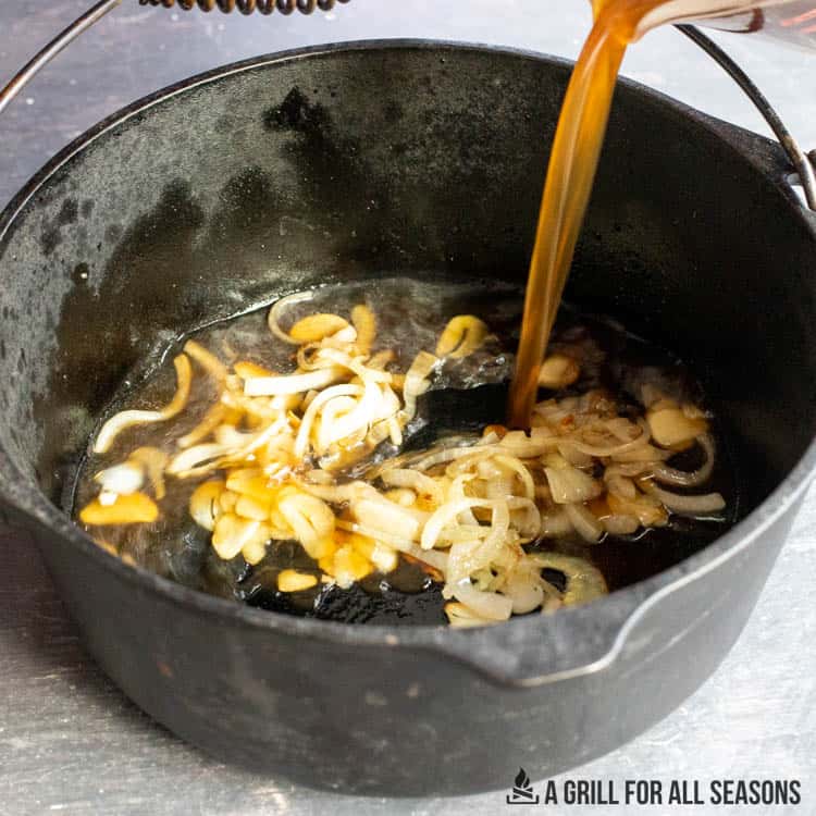 adding stock to sauteed onions and garlic