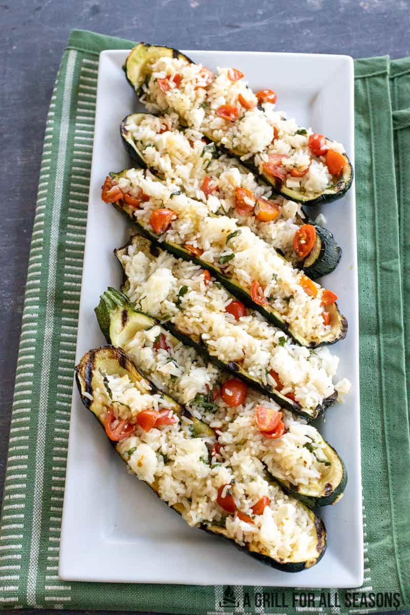 plated grilled stuffed zucchini on a white serving platter