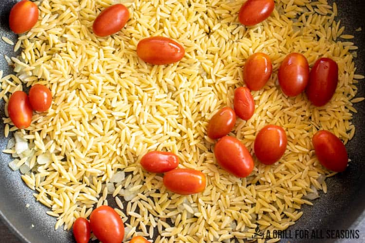 cherry tomatoes and orzo in a pan