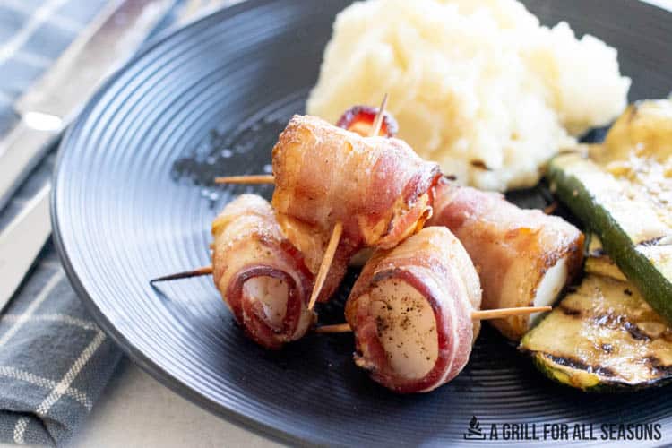bacon wrapped cod bites on plate with zucchini and mashed potatoes