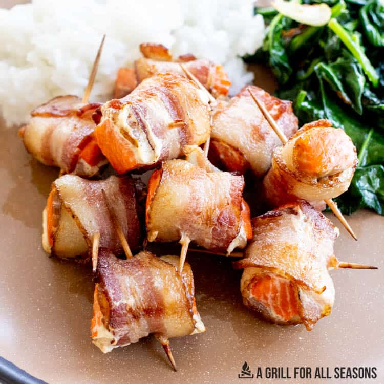 bacon wrapped salmon appetizers with mashed potatoes and spinach