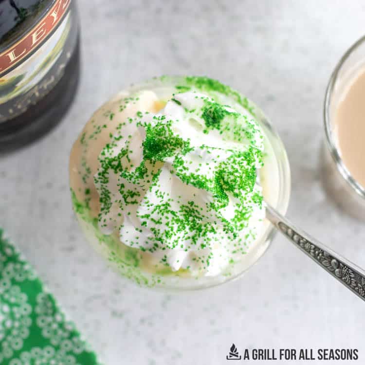 dish of ice cream topped with whipped cream and green sprinkles