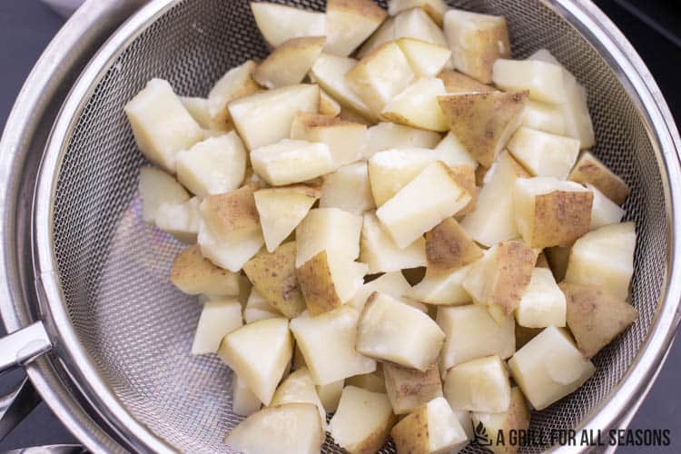 boiled potatoes draining in strainer