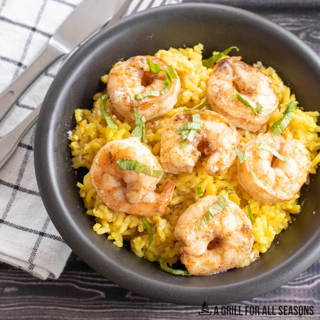 butter poached shrimp on top of yellow rice