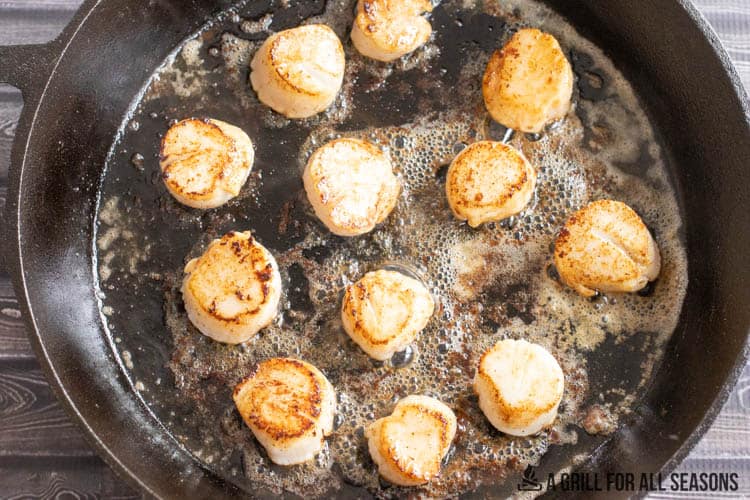 cast iron skillet cooking scallops in butter