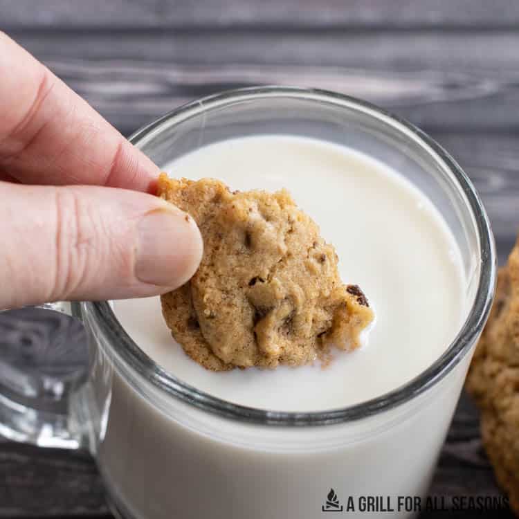 hand dunking a smoked cookie in milk