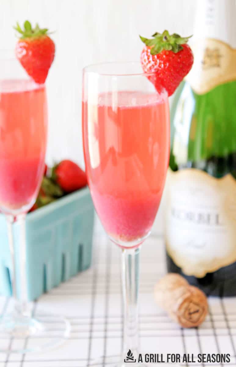 glasses of strawberry mimosas garnished with a fresh berry