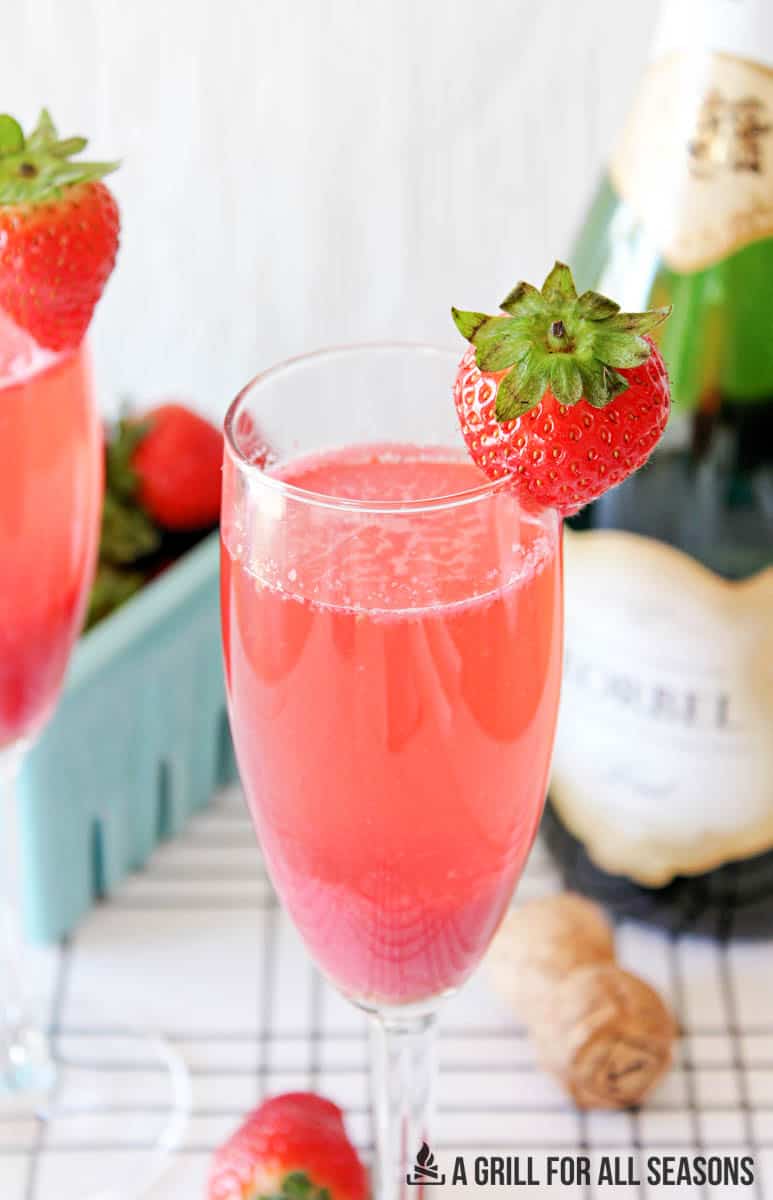 close up of glasses of strawberry mimosas garnished with a fresh berry