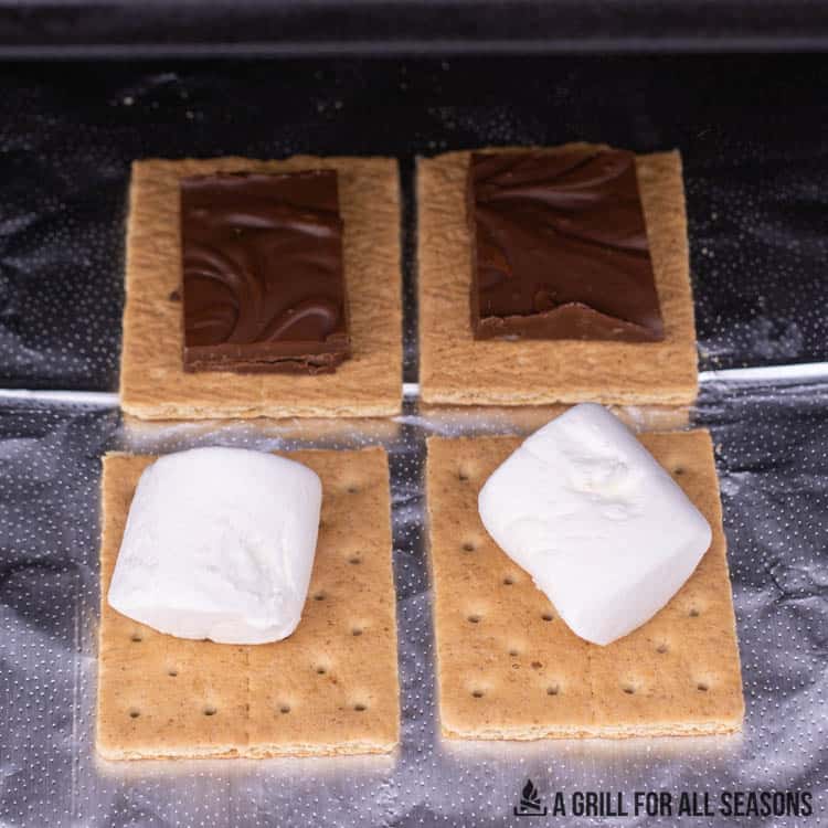 4 graham cracker halves topped with melting chocolate and marshmallows