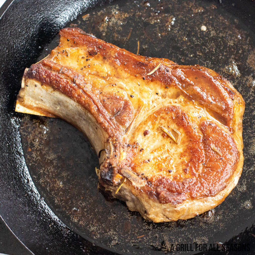 cooked berkshire pork chop in cast iron pan