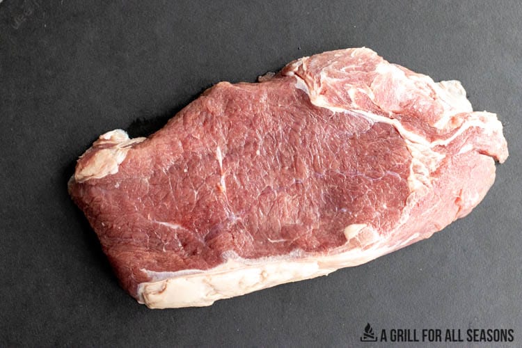 uncooked steak on cutting board