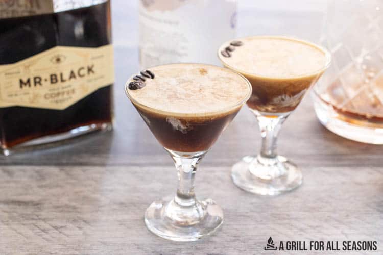 creamy espresso martini with ingredients behind