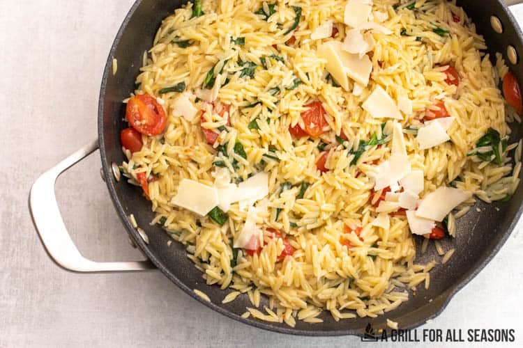 orzo in skillet with spinach and tomatoes