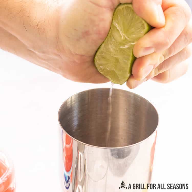 lime being squeezed into a metal cup