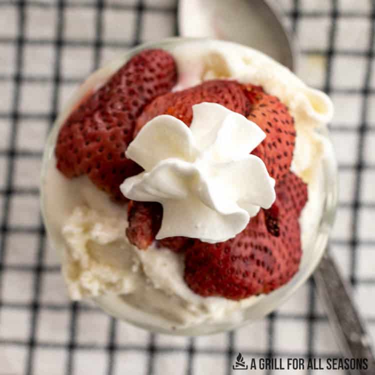 smoked strawberries with whip cream and ice cream in a cup