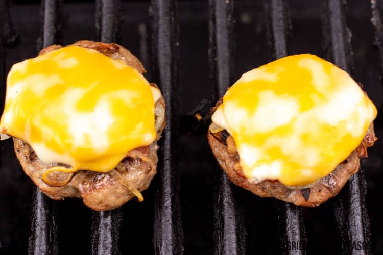 wild boar burger on grill with cheese