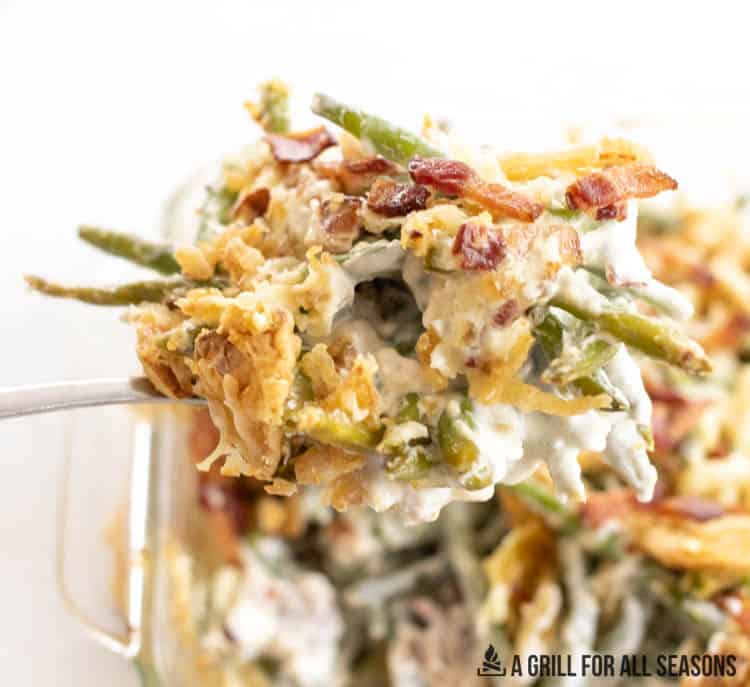 spoon lifting up serving of loaded green bean casserole recipe with cream cheese