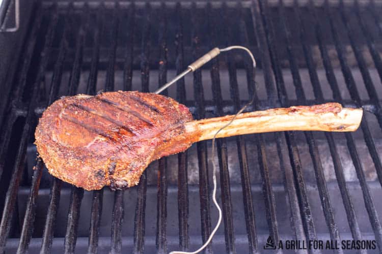 tomahawk steak on smoker with temperature probe