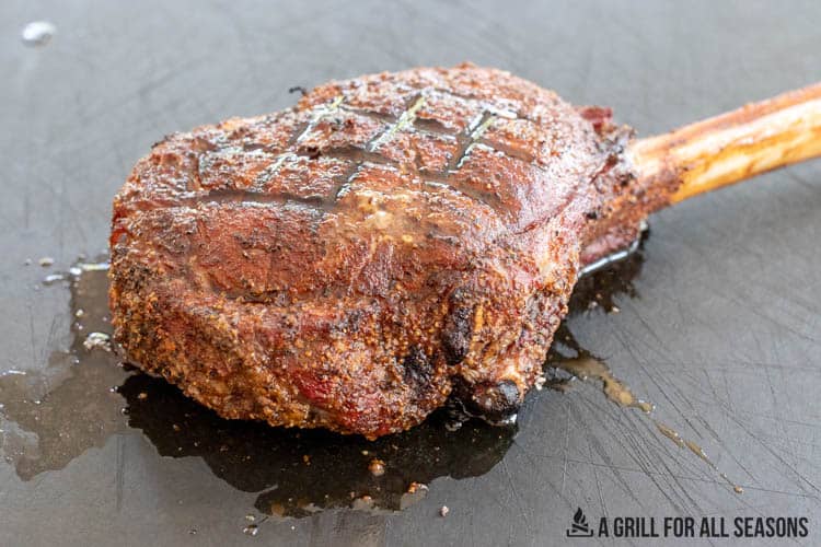 smoked tomahawk steak on cutting board