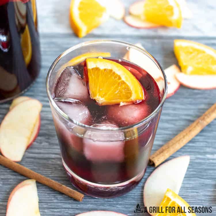 rocks glass full of sangria topped with orange wedge slice