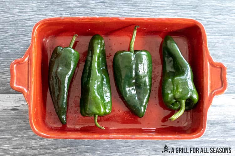 poblano peppers in a roasting dish