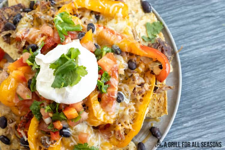 nachos topped with pulled pork and other toppings