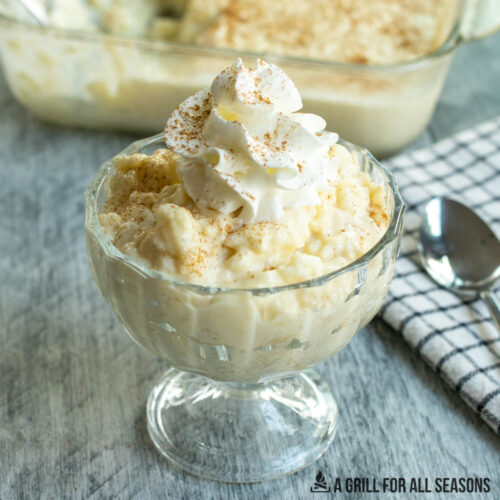 irish rice pudding recipe in glass dish topped with whipped cream and cinnamon