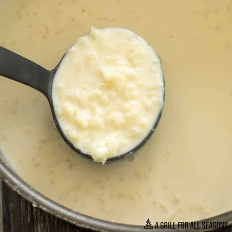 ladle lifting up rice cooked in milk