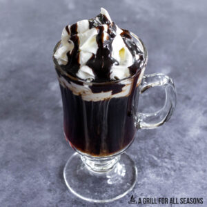 coffee nudge recipe in glass mug  topped with whipped cream and chocolate sauce