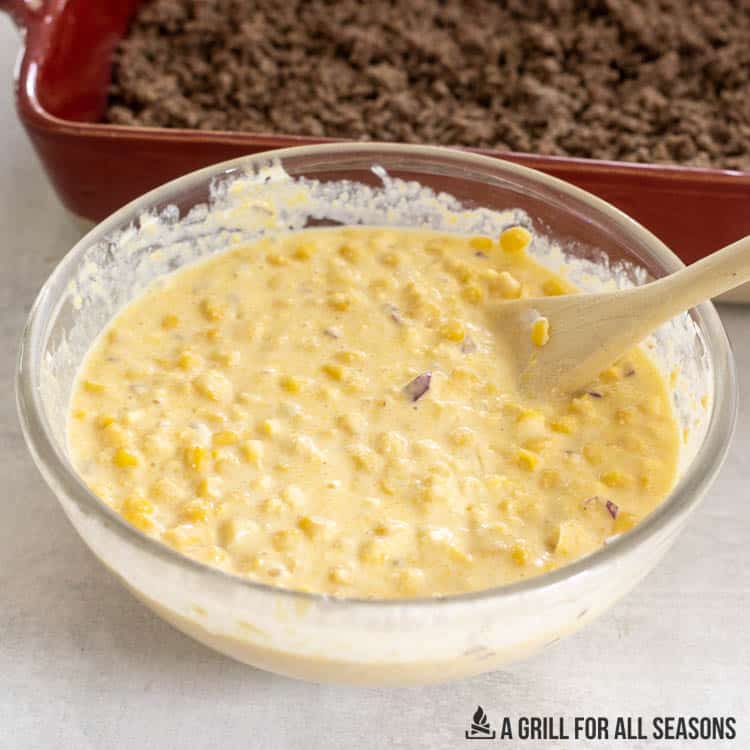 casserole dish with browned beef and bowl of corn mixture