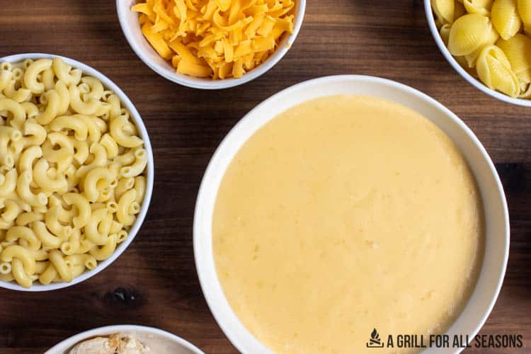 bowls of cheese sauce, noodles, and cheese