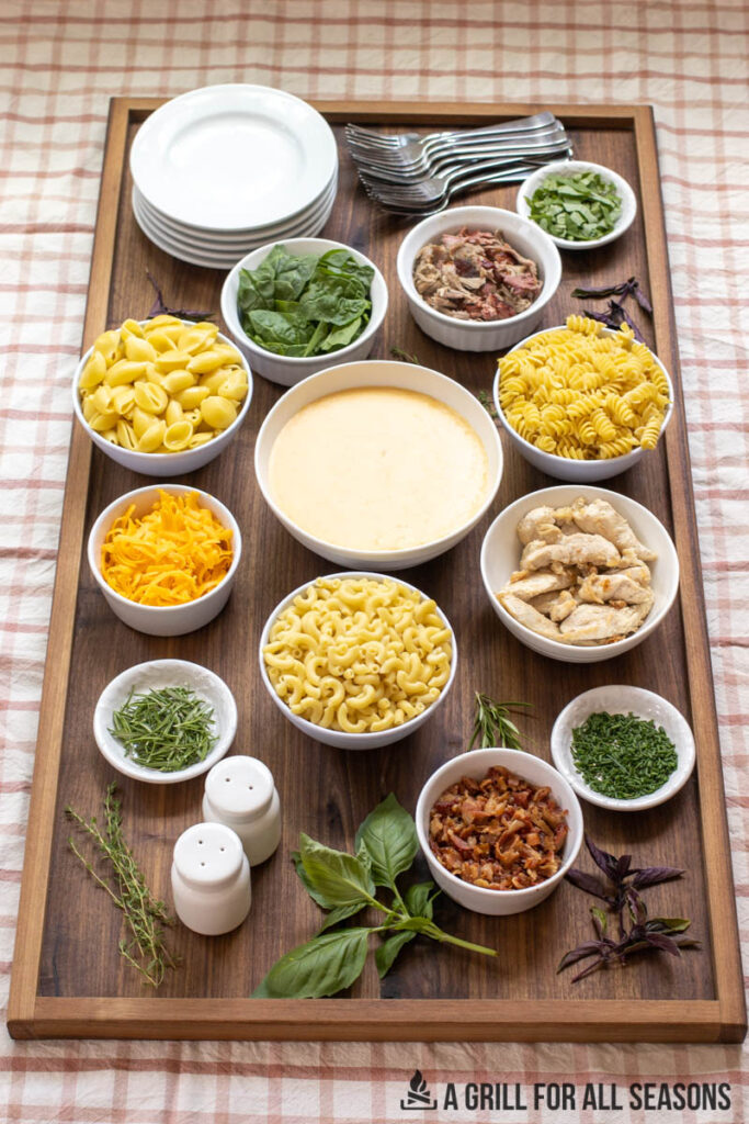mac and cheese charcuterie board with bowls of toppings and ingredients