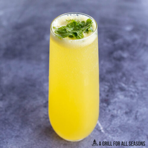 tropical mojito recipe with passion fruit juice served in a stemless champagne glass with mint