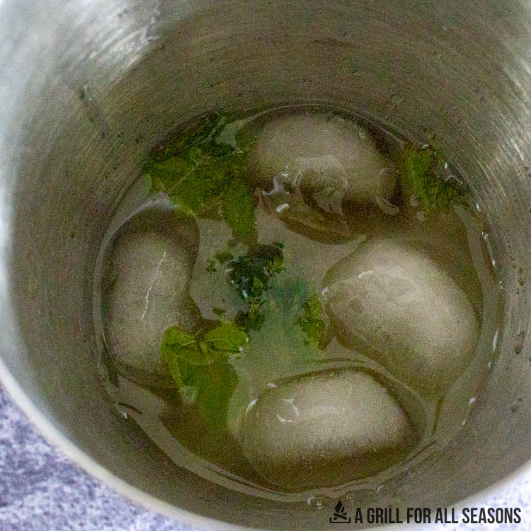 ice cubes and mint in cocktail shaker with juices and rum