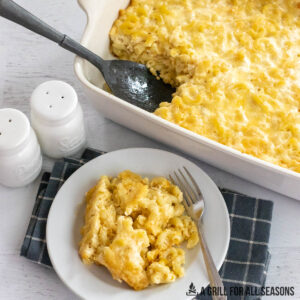 baked mac and cheese on small plate with casserole behind