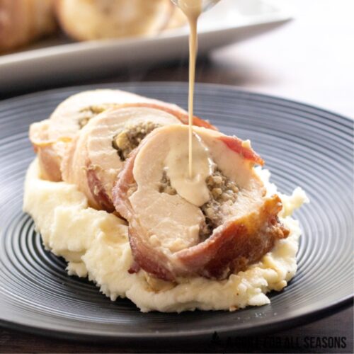 Balmoral chicken recipe sliced and placed a top mashed potatoes on a plate getting drizzled with a whisky cream sauce.