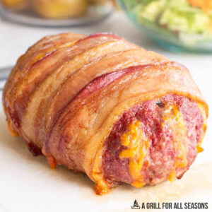 smoked meatloaf recipe wrapped in bacon resting on cutting board