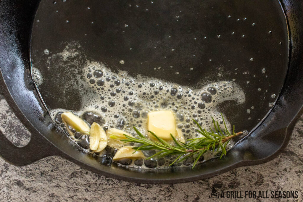 garlic and rosemary cooking in butter in cast iron skillet