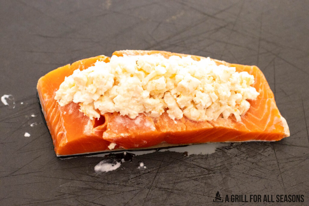 filet portion of salmon stuffed with shrimp on cutting board