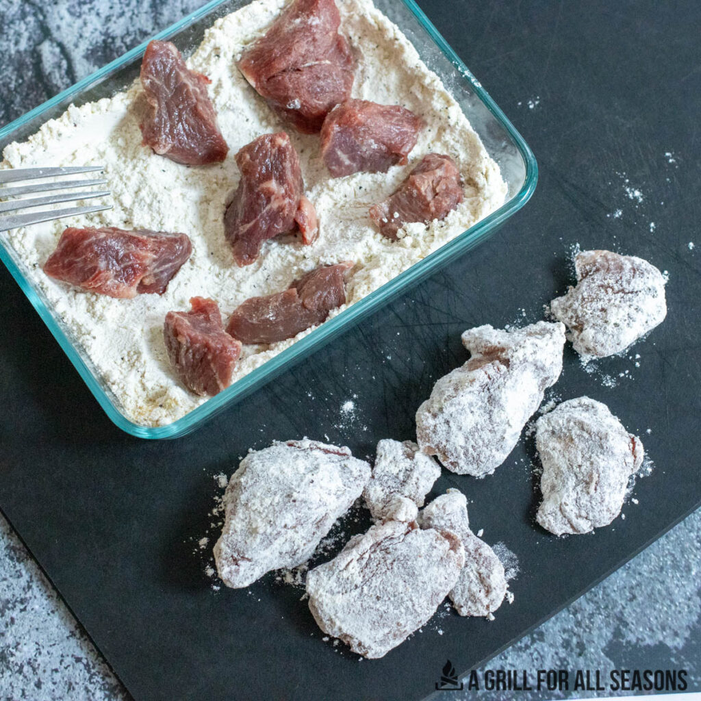 coating beef cubes with seasoned flour