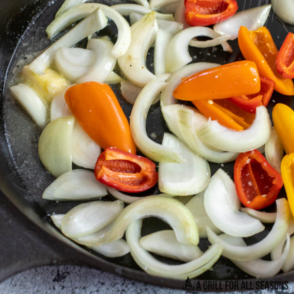 onions and peppers in skillet