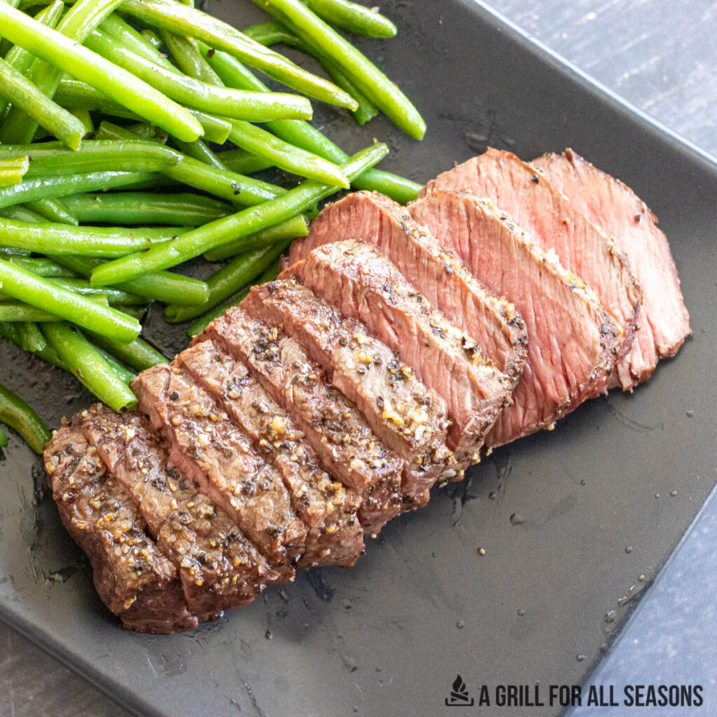 denver steak served on rectangle plate with green beans