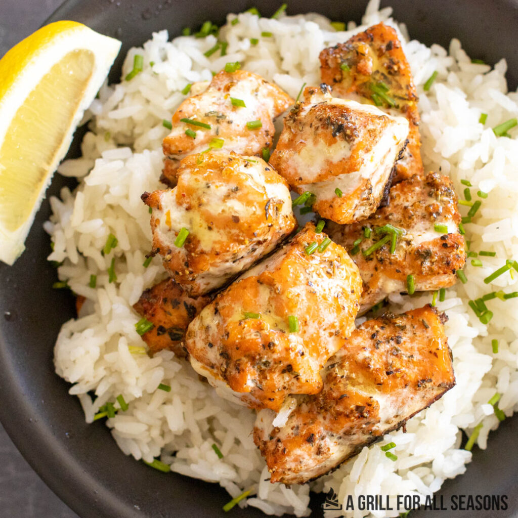 grilled cajun salmon bites on top of bed of rice