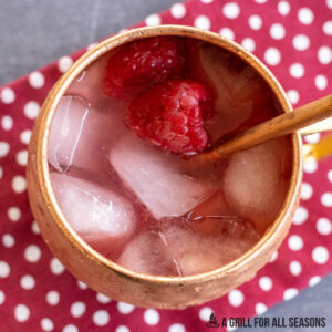 raspberry mule recipe garnished with fresh berries served in copper mug