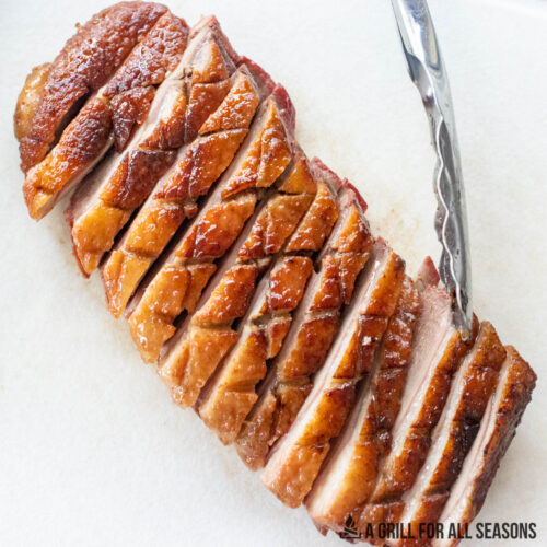 smoked duck breast sliced on a cutting board