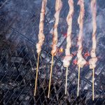 bacon on a stick cooking on charcoal grill