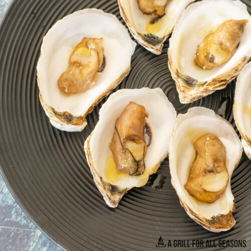 smoked oysters recipe on the half shell served on a black platter